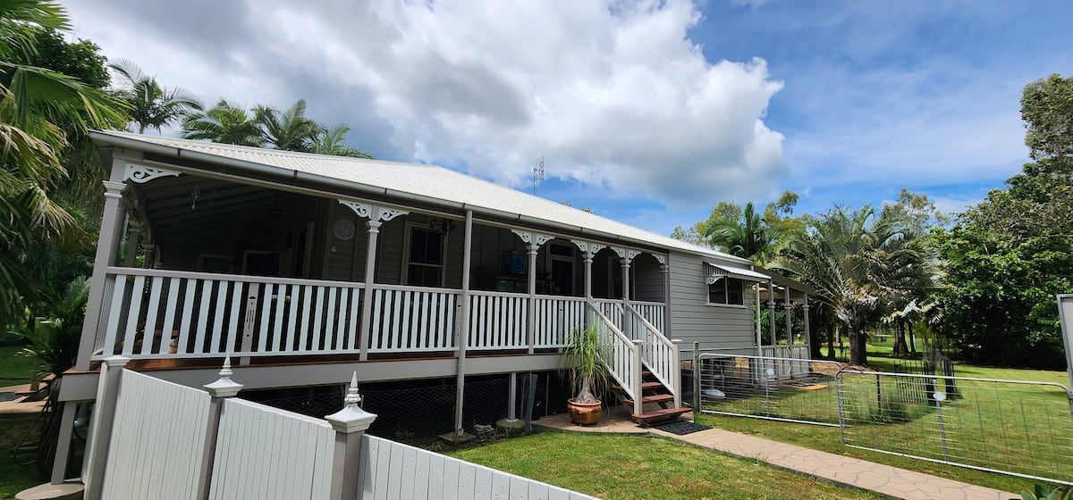 A Large White House With a White Fence in Front of It — Gaspen Builders & Carpenters in Kirwan, QLD