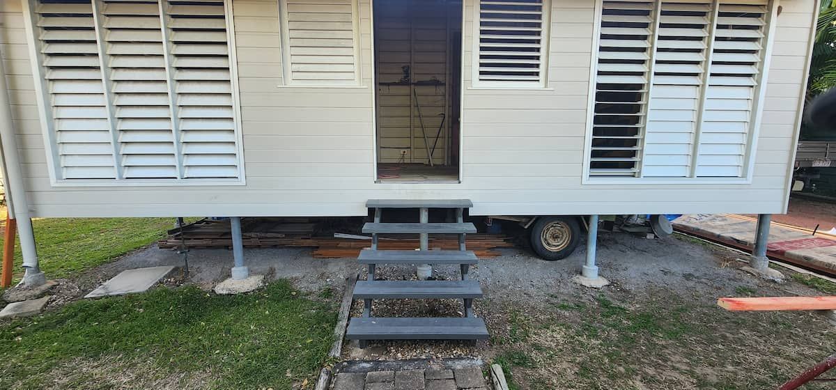 A Small White House With Stairs Leading Up to It — Gaspen Builders & Carpenters in Kirwan, QLD