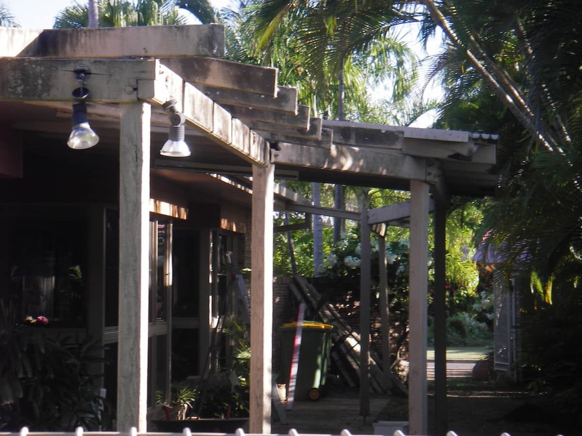 A Wooden Pergola With a Few Lights Hanging From It — Gaspen Builders & Carpenters in Kirwan, QLD