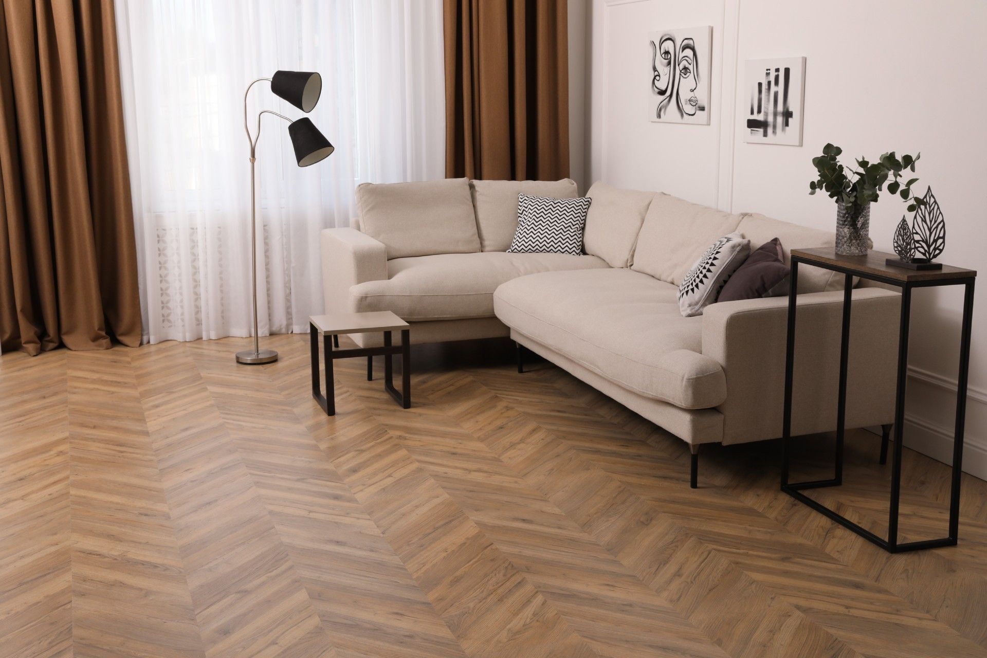 A living room with a sectional couch and a wooden floor.