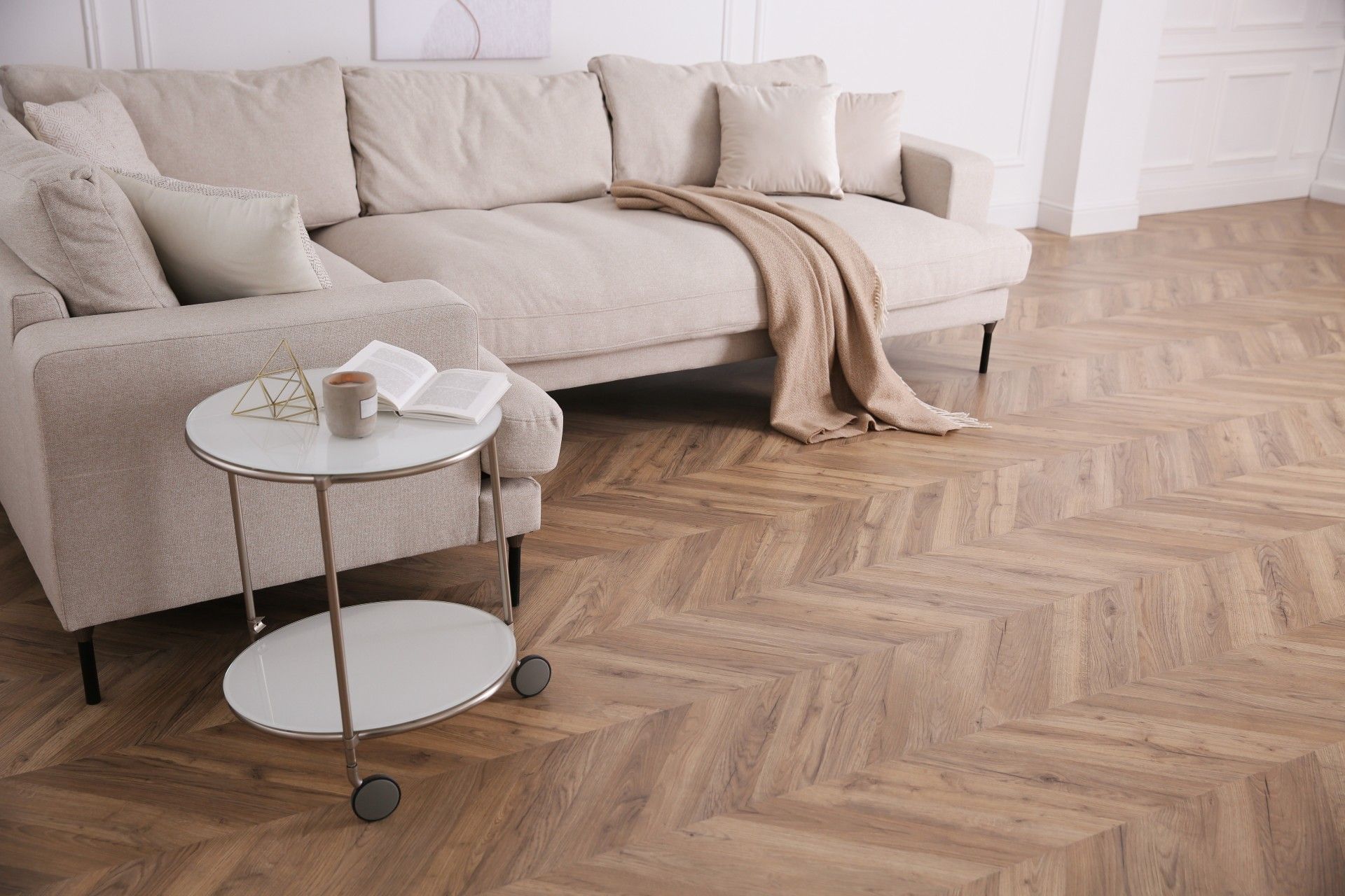 A living room with a couch , chair , table and wooden floor.