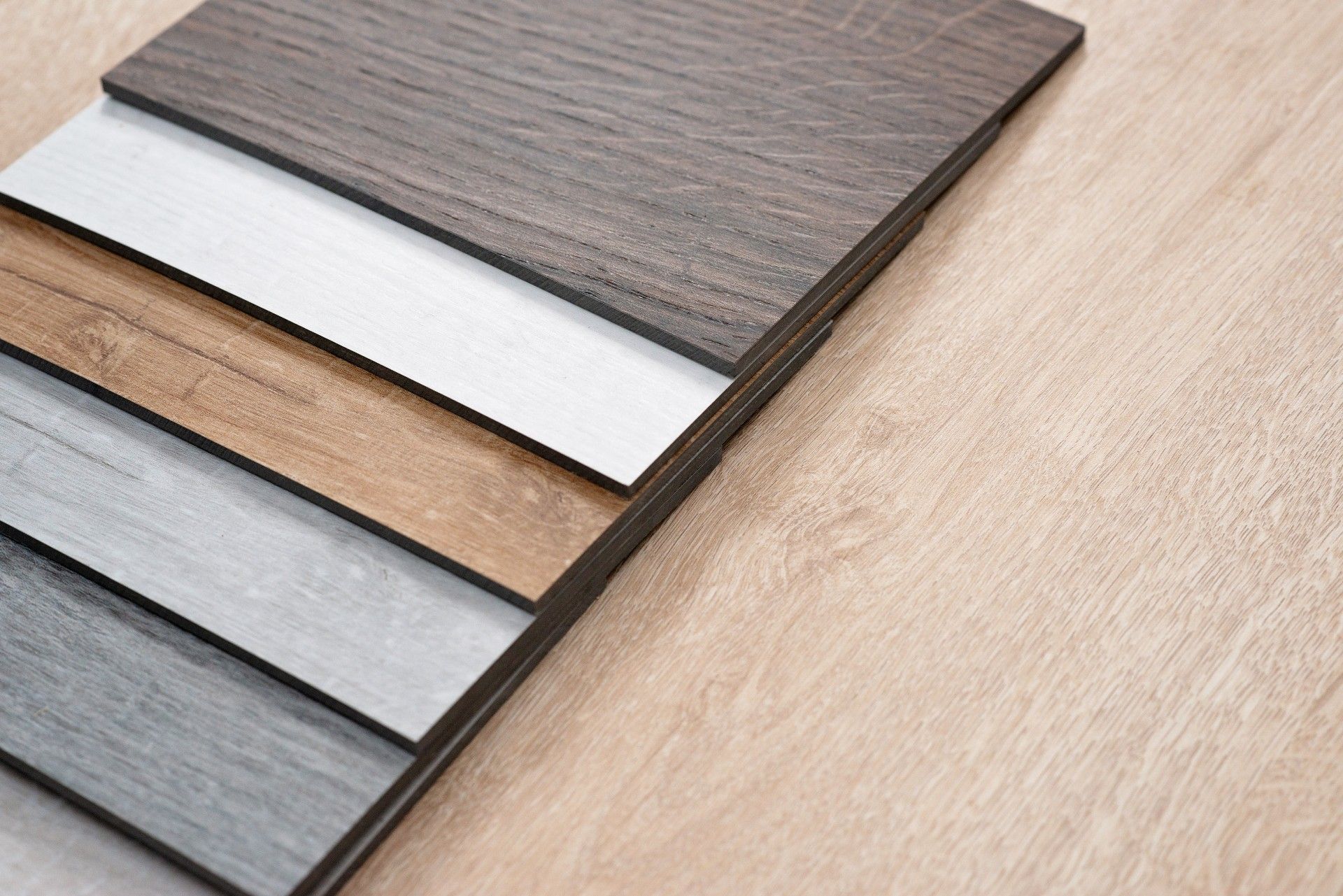 A stack of different colored wooden boards on a wooden table.
