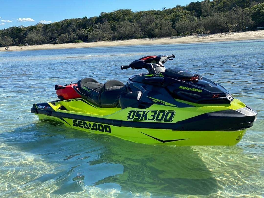 A yellow and black jet ski is floating on top of a body of water.