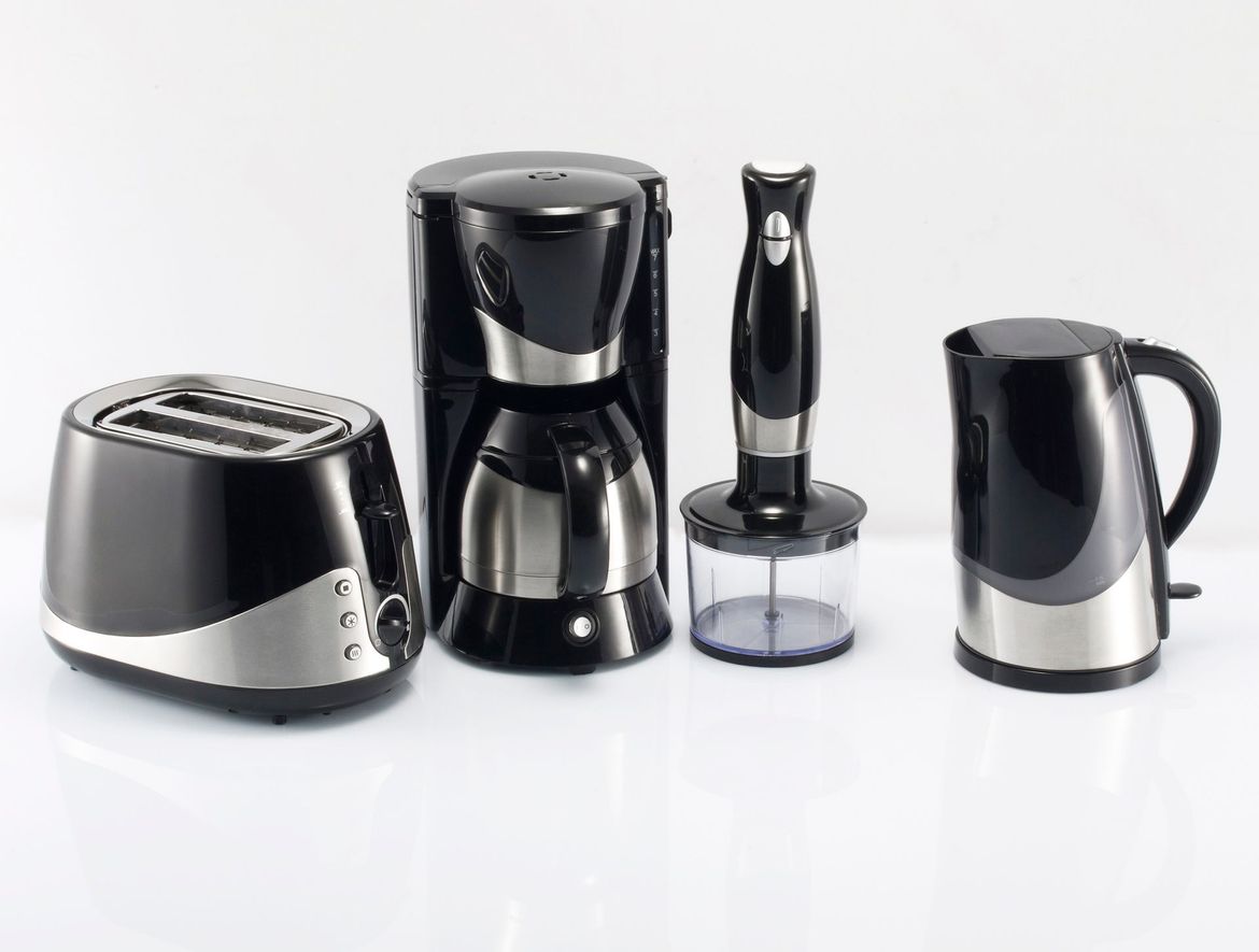Elettrodomestici da cucina neri e argento: tostapane, macchina per il caffè, frullatore a immersione e bollitore elettrico.