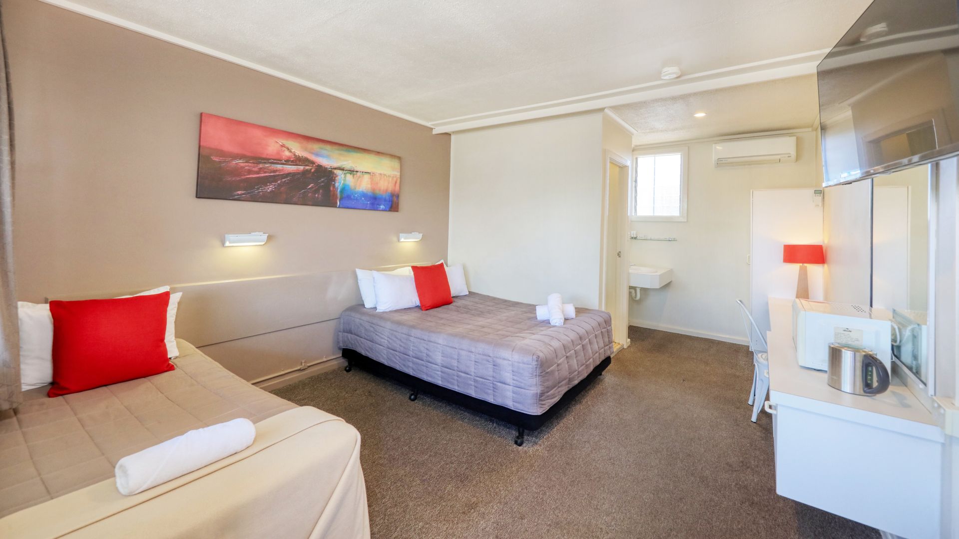 A hotel room with two beds and a sink.