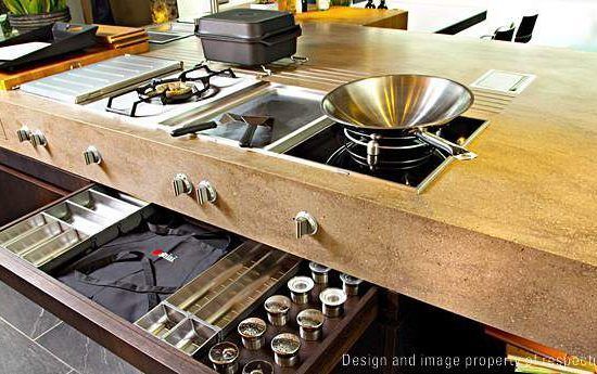 Built-in kitchen island with stovetop, sink, utensils, and open drawers holding cookware and cups