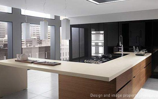 Modern open-plan kitchen with a light wood island, white counters, and dark cabinetry, overlooking city buildings