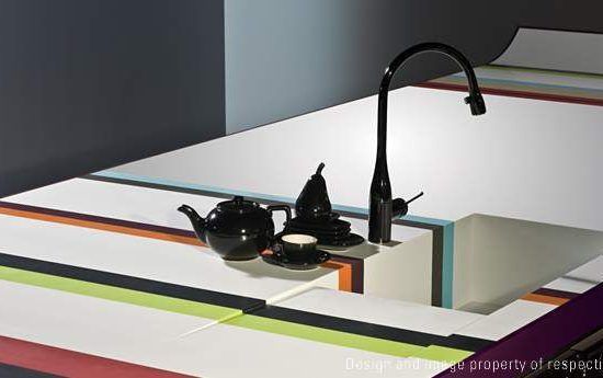 Modern kitchen sink with black faucet and a teapot on a white countertop