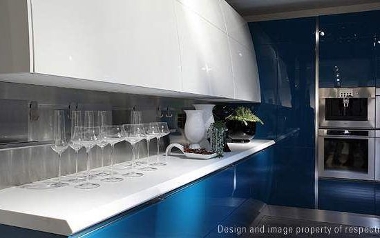 Modern blue-and-white kitchen with a glossy counter, wine glasses, and built-in ovens