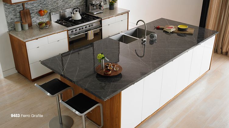 Modern kitchen with a large dark island, white cabinets, and stainless steel appliances
