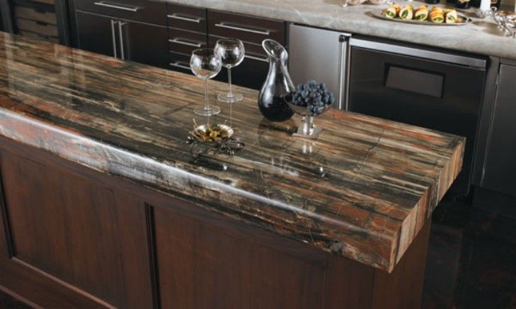 Dark wood kitchen island with a polished stone countertop and decorative glassware.