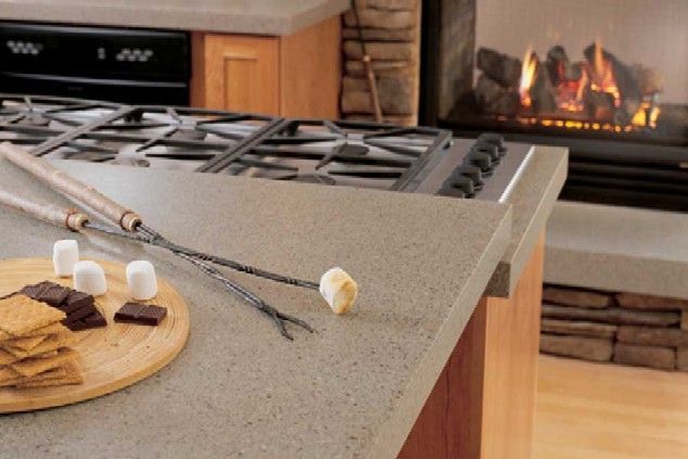 Marshmallows on skewers beside a countertop, with a lit fireplace in the background