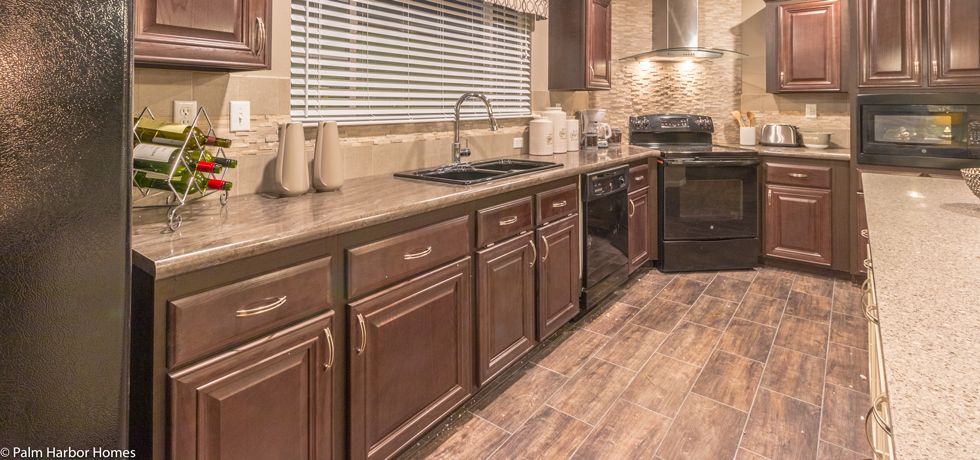 Modern kitchen with dark wood cabinets, granite counters, stainless sink, and wood-look flooring