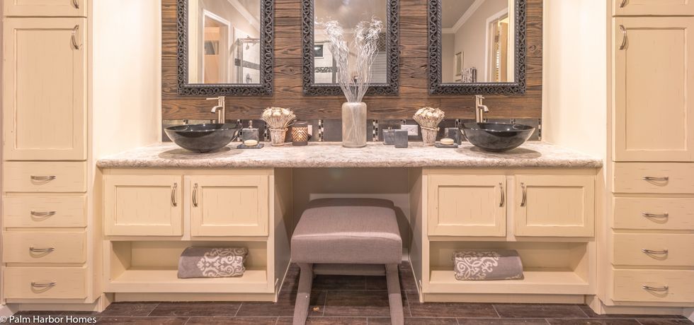 Elegant cream vanity with mirror, drawers, and stool in a luxurious bathroom.