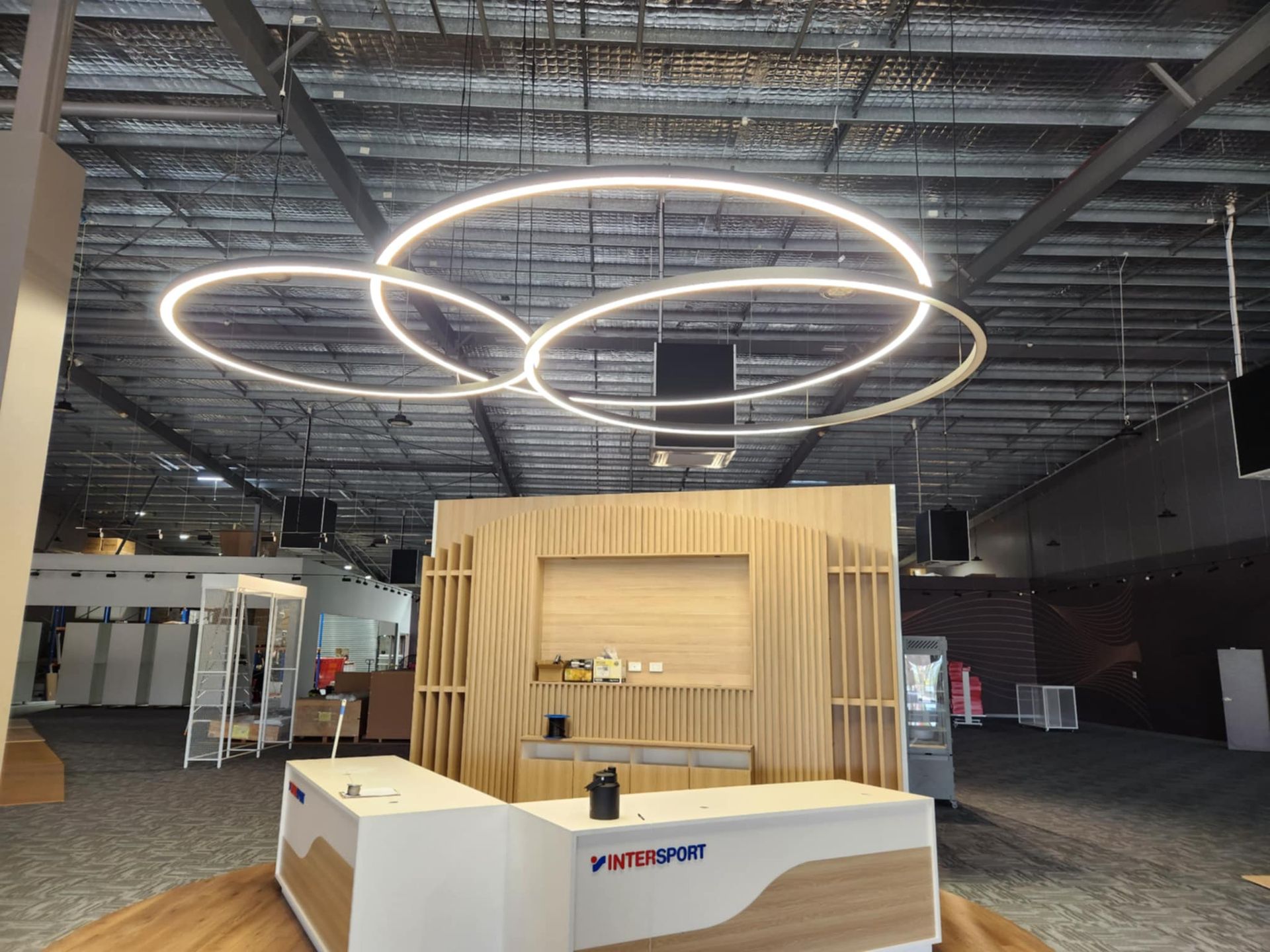 Modern display setup with circular lights hanging above a wooden counter — Watkins Electrical In Pialba, QLD