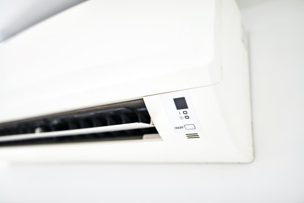 A White Air Conditioner is Hanging on a White Wall — Watkins Electrical In Pialba, QLD