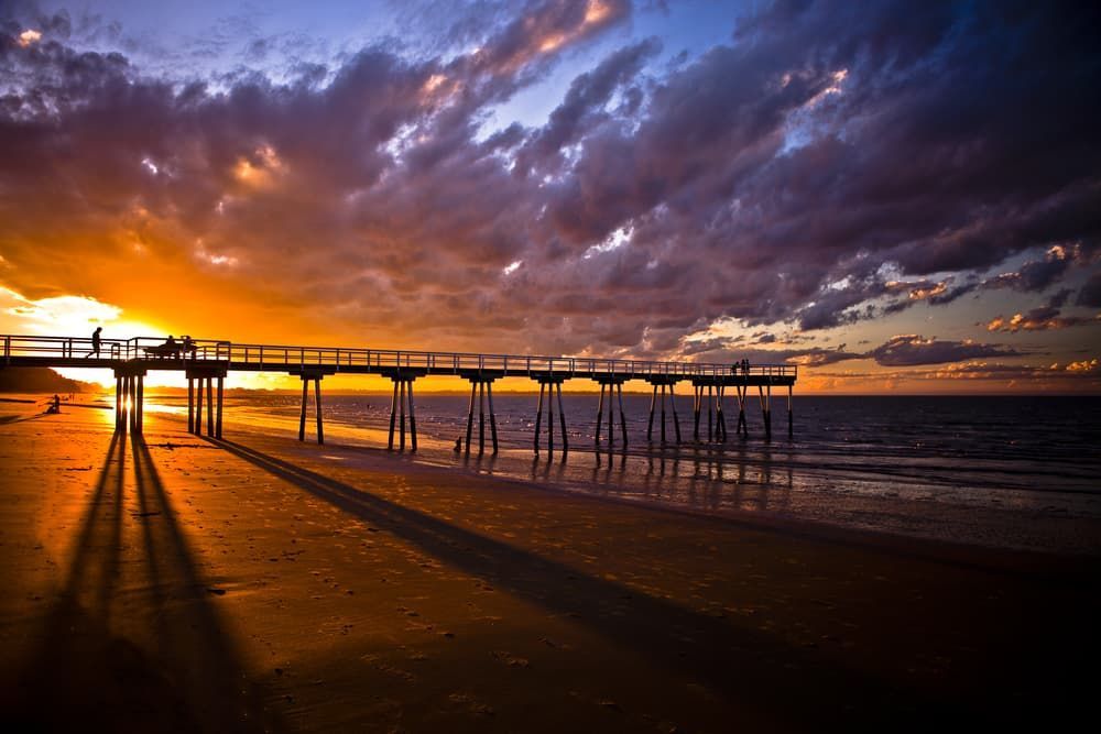 There is a Pier on the Beach at Sunset — Watkins Electrical In Pialba, QLD