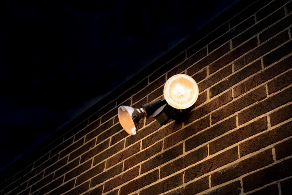 A Brick Wall With a Light on It at Night — Watkins Electrical In Pialba, QLD