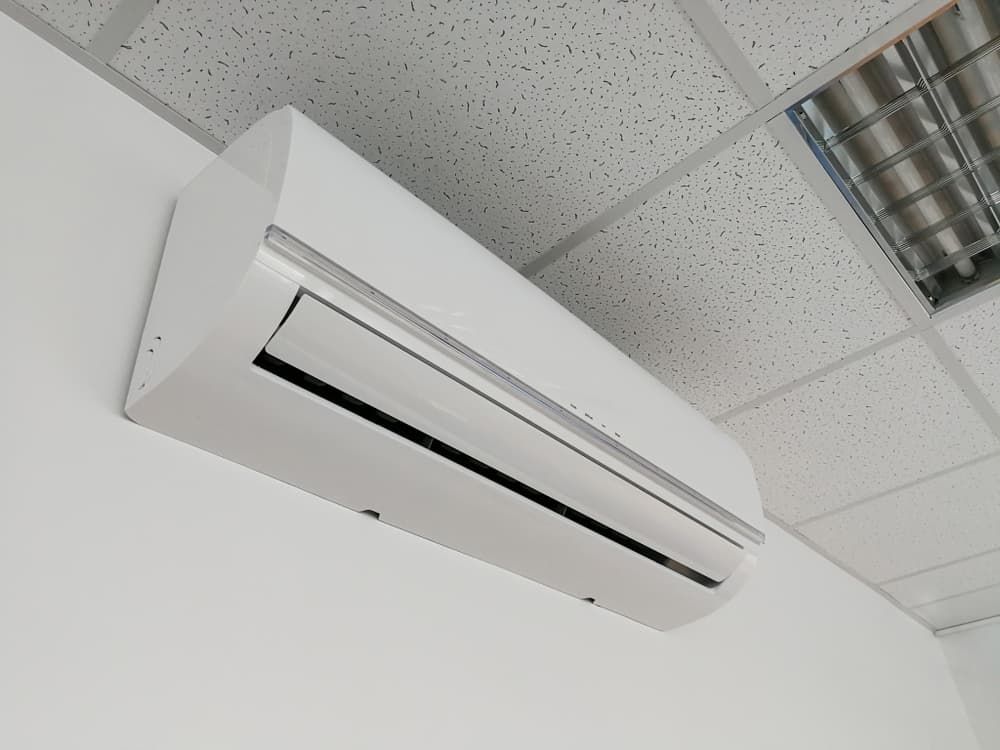 A White Air Conditioner is Hanging From the Ceiling — Watkins Electrical In Maryborough, QLD