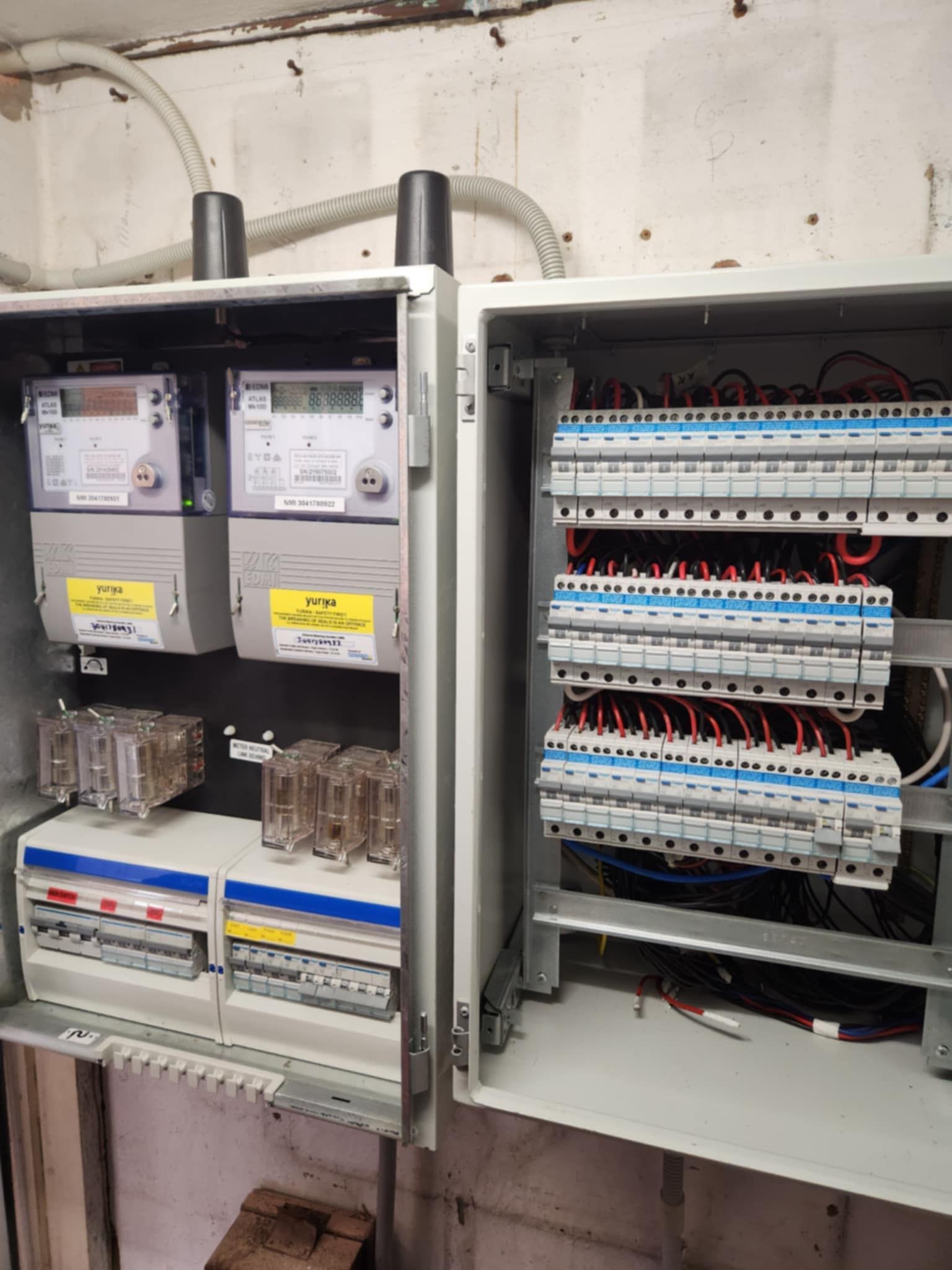 Electrical panel with meters, circuit breakers, and wiring — Watkins Electrical In Pialba, QLD