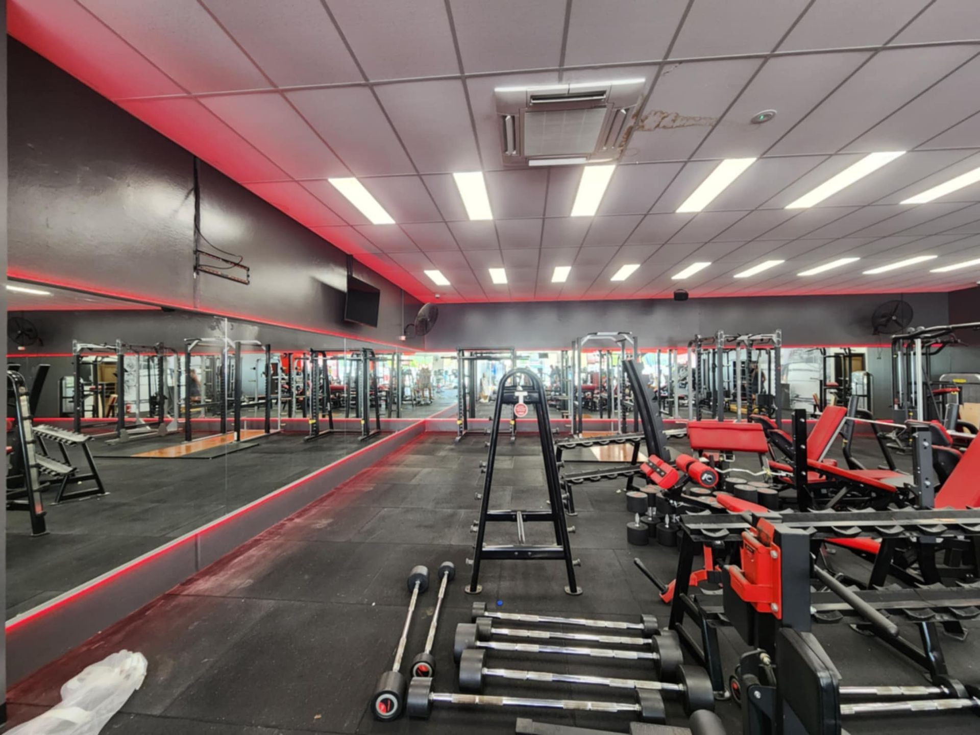 Gym interior with mirrors, weights, and exercise equipment — Watkins Electrical In Pialba, QLD