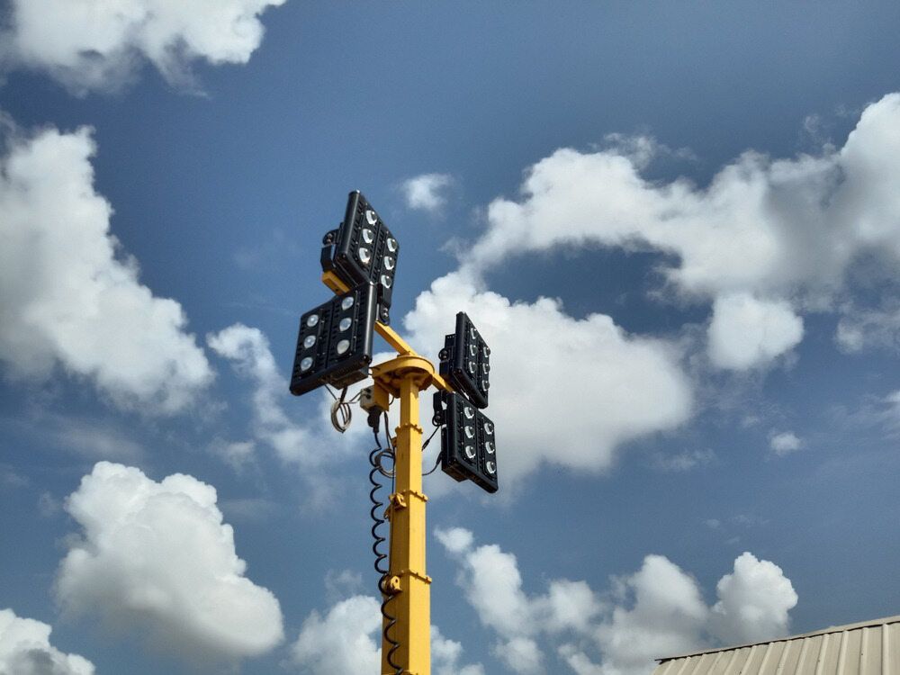 Yellow Mobile Light Tower Against a Cloudy Blue Sky — Watkins Electrical In Maryborough, QLD