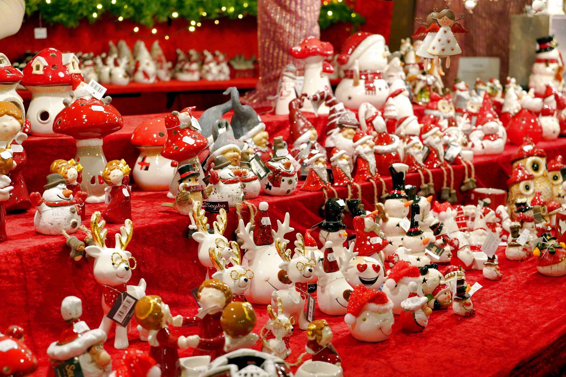 Diverse rood-witte kerstbeeldjes uitgestald op een feestelijke tafel.