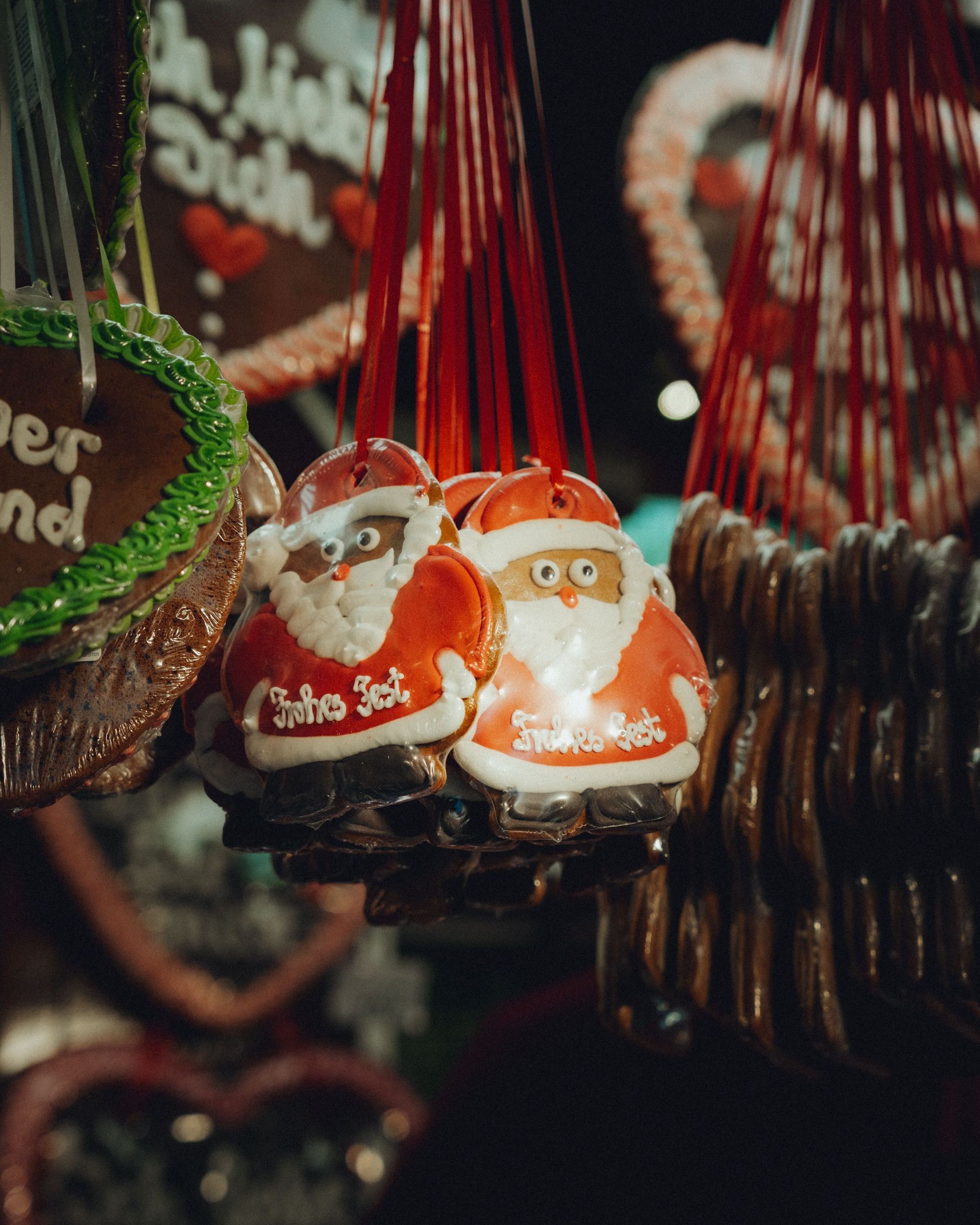 Rode en oranje kerstmanornamenten hangen tussen andere feestelijke kerstversieringen.