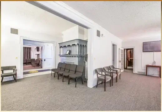 Spacious waiting room with rows of chairs, a reception desk, and open doorways in a beige interior.
