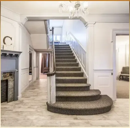 Elegant foyer with carpeted staircase, white walls, chandelier, and tiled floor