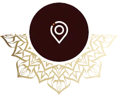White location pin on dark brown circle above gold floral geometric pattern