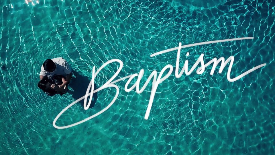 Person standing in turquoise water with the word “Baptism” written across the image