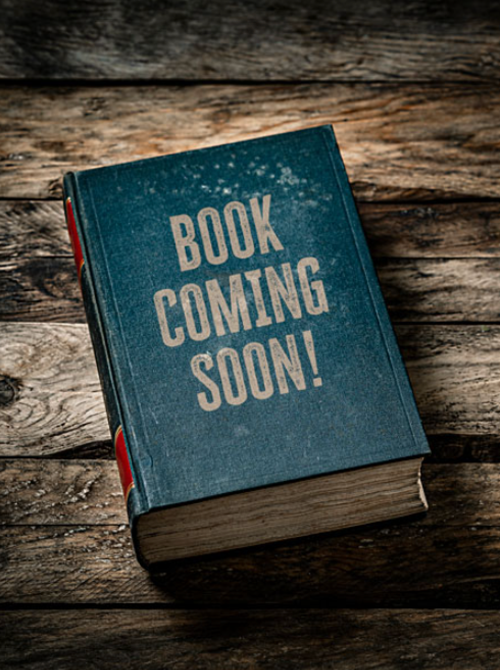 Blue book on wooden table with bold text “BOOK COMING SOON!” for Daniel Sterling