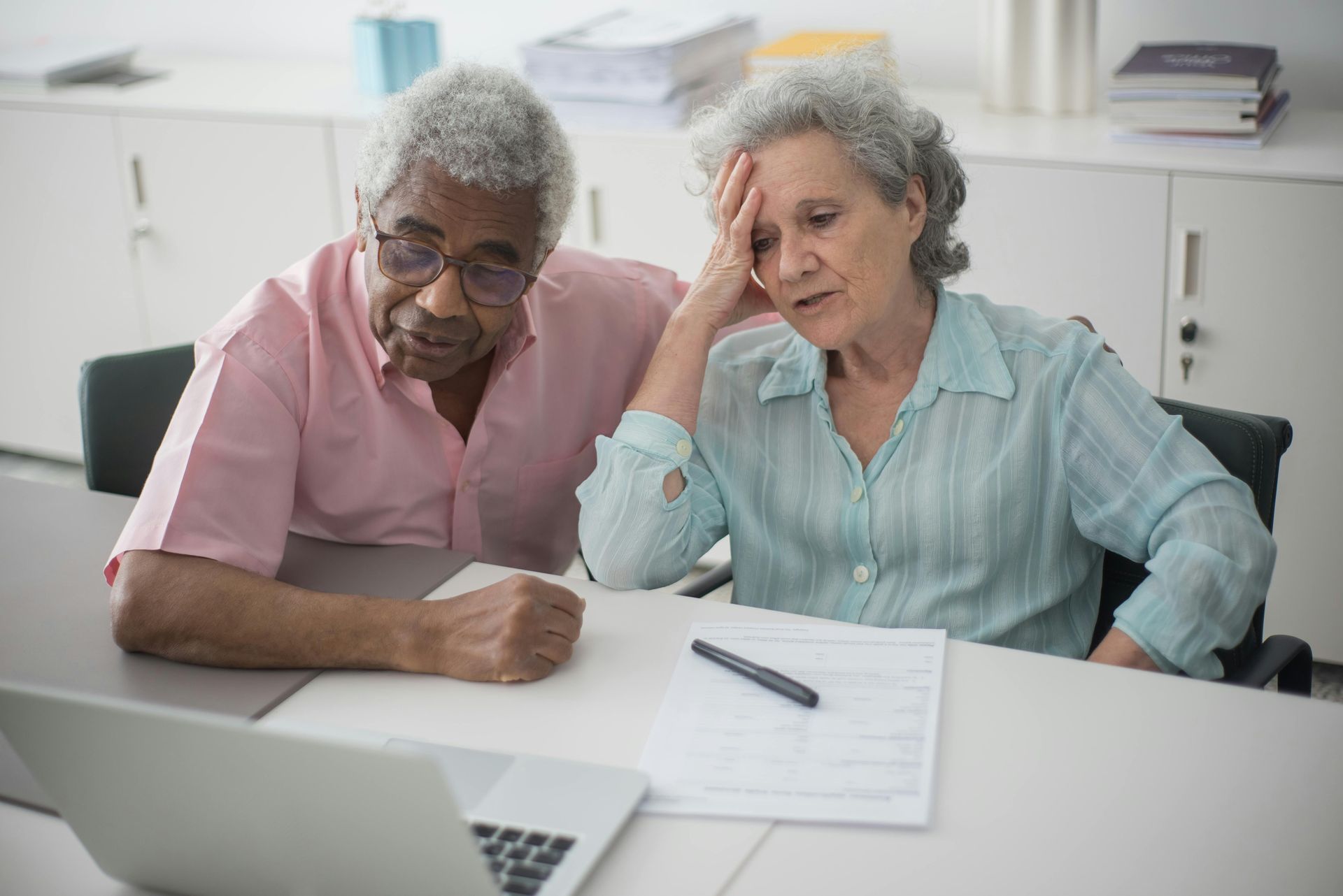elderly couple sat at desk reviewing paperwork
