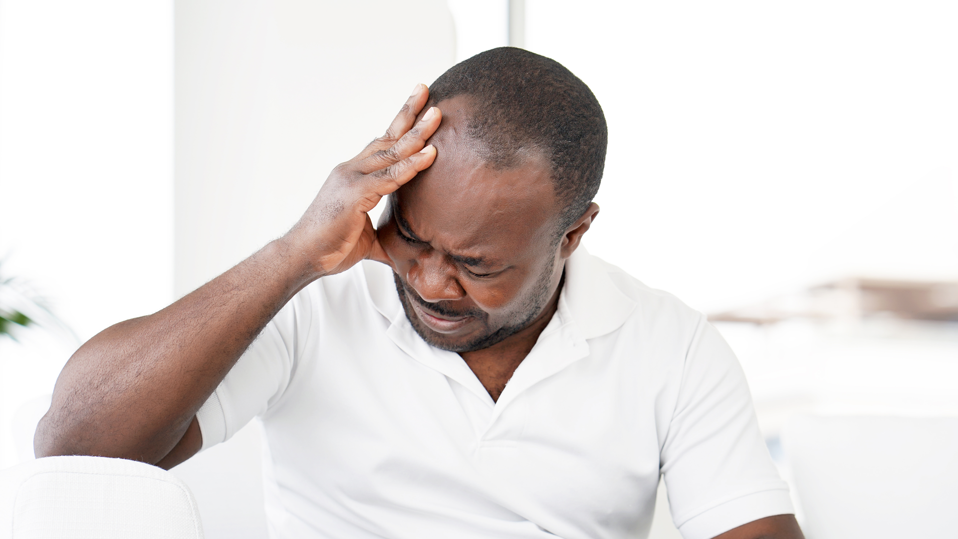 Guy holding his head because he has a headache from grinding his teeth