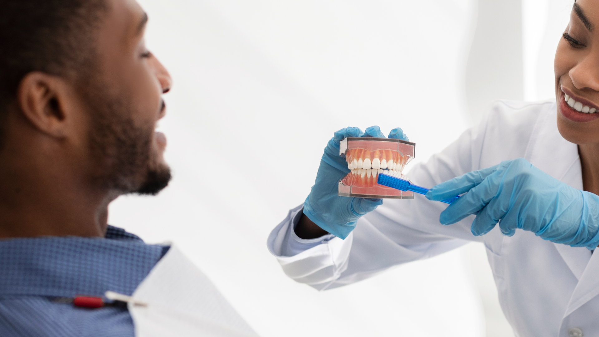 Dentist showing a dental model to a patient during a consultation