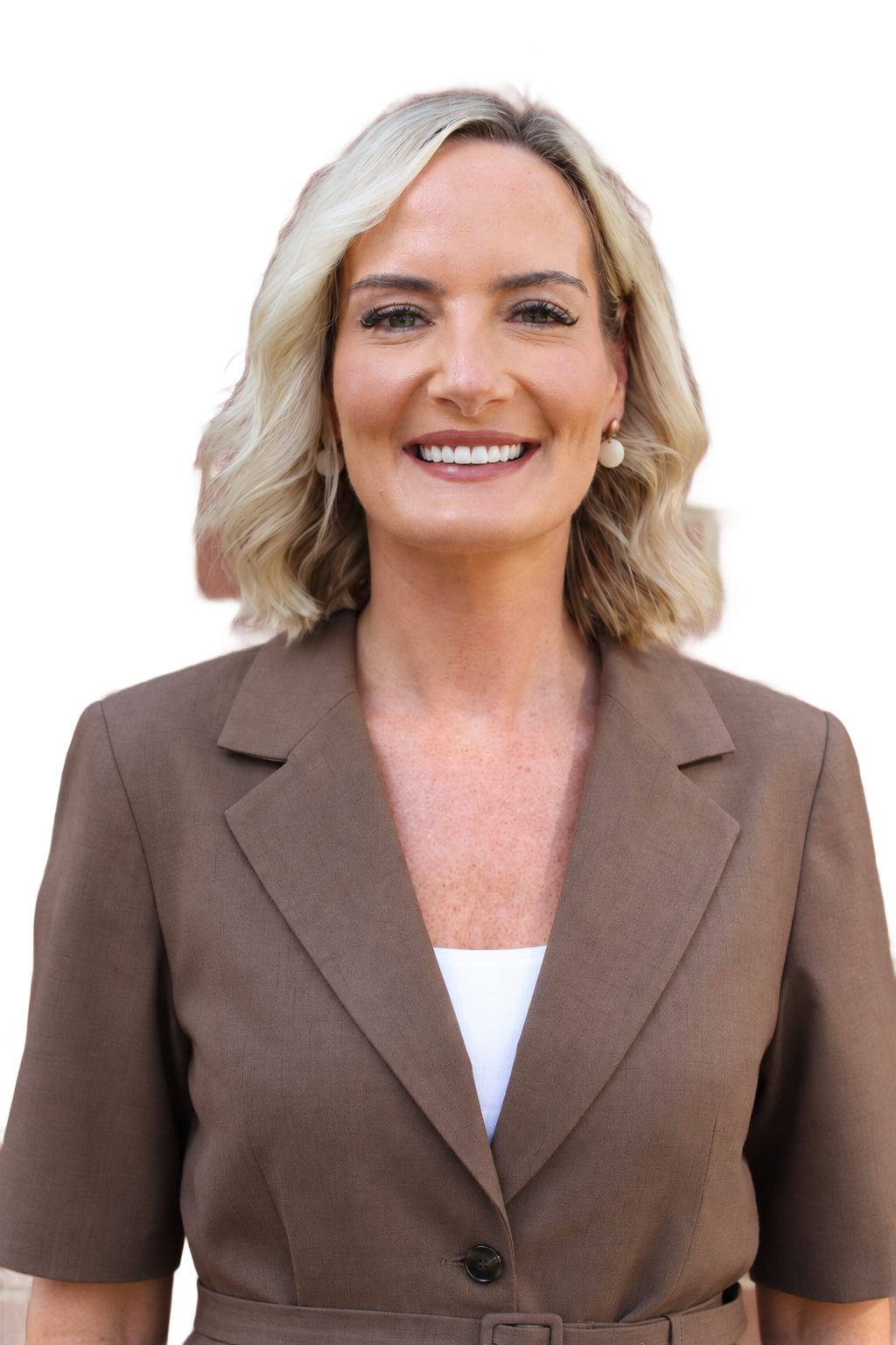 Smiling professional in a blazer, posed against a plain light background.