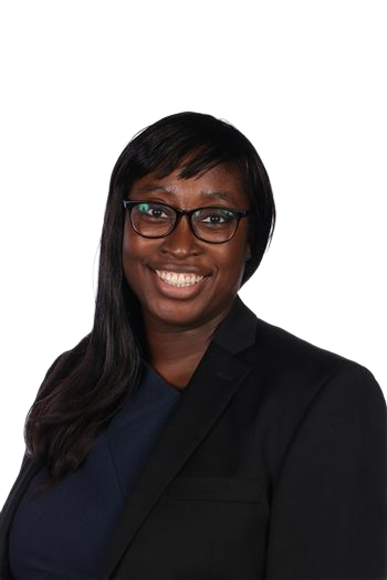 Smiling person in glasses and a blazer against a plain white background