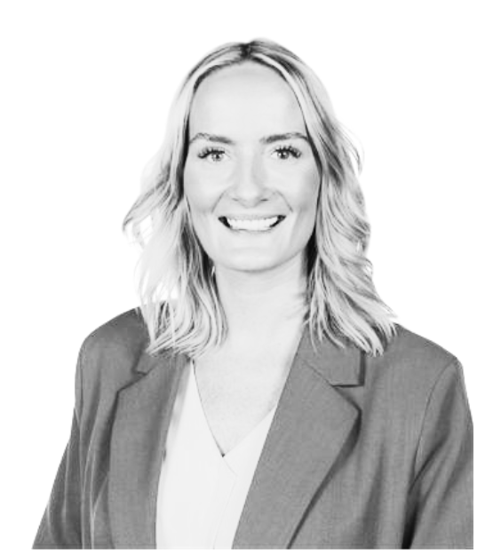 Smiling professional in a blazer, posed against a plain light background.