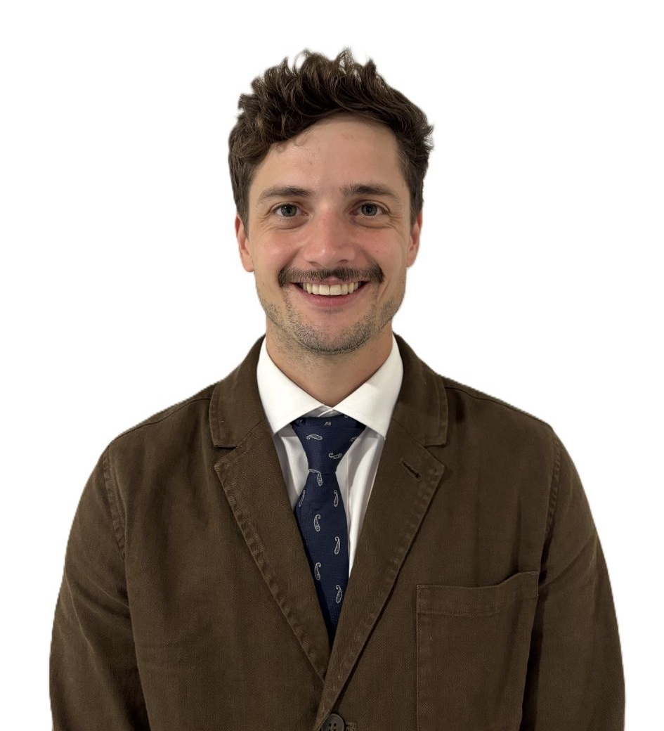 Studio portrait of a man in a dark suit and patterned tie against a white background