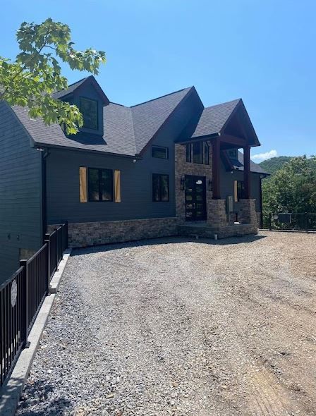 A large house with a gravel driveway in front of it