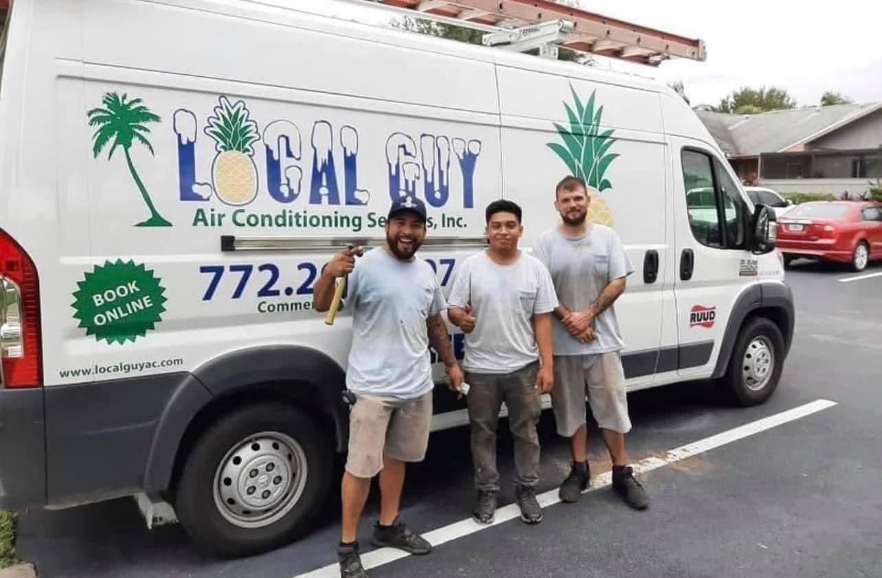 A group of Local Guy technician standing in front of a van that says local guy