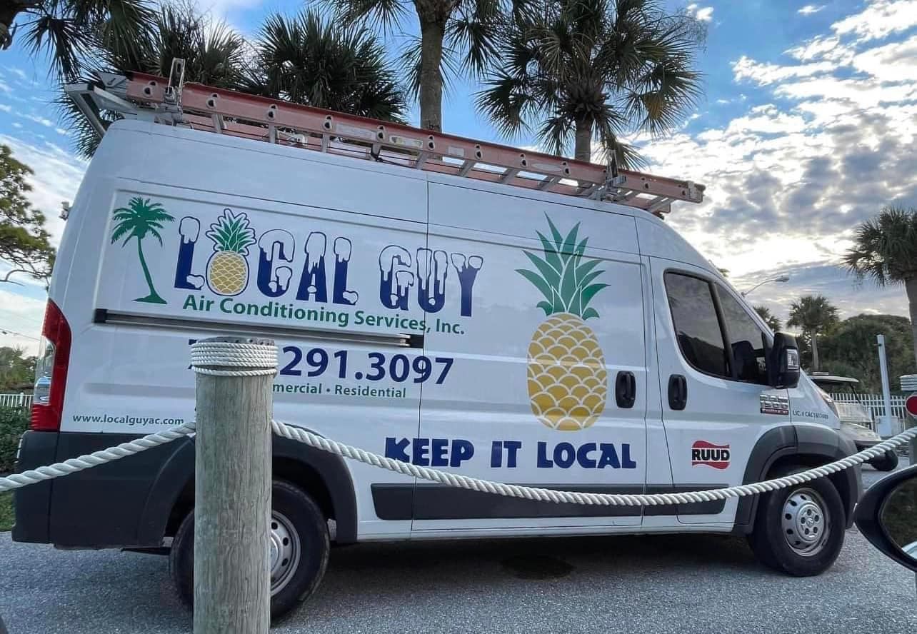 A Local Guy van with a pineapple on the side is parked in a parking lot.