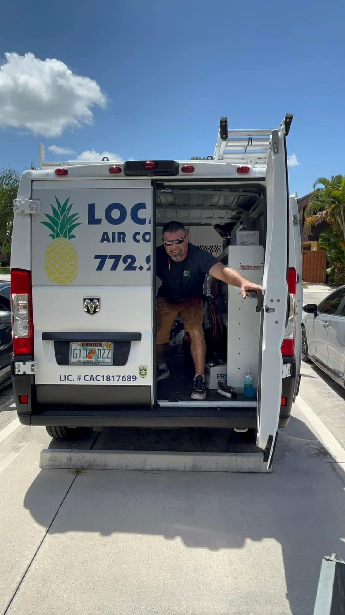 A Local Guy technician is standing in the back of a van.