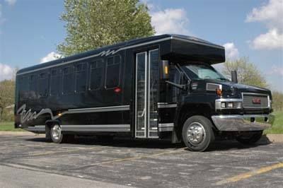 A black bus is parked on the side of the road.