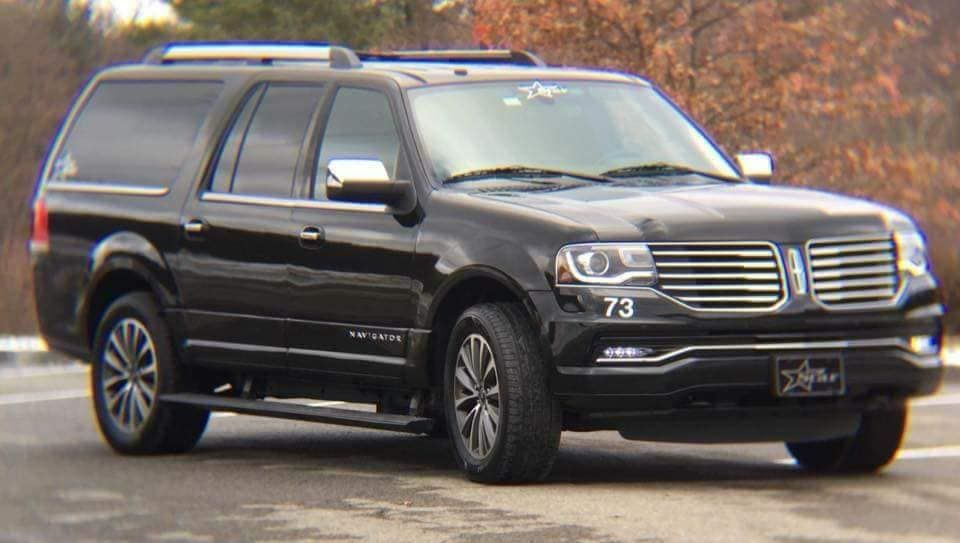 A black ford expedition is parked on the side of the road.
