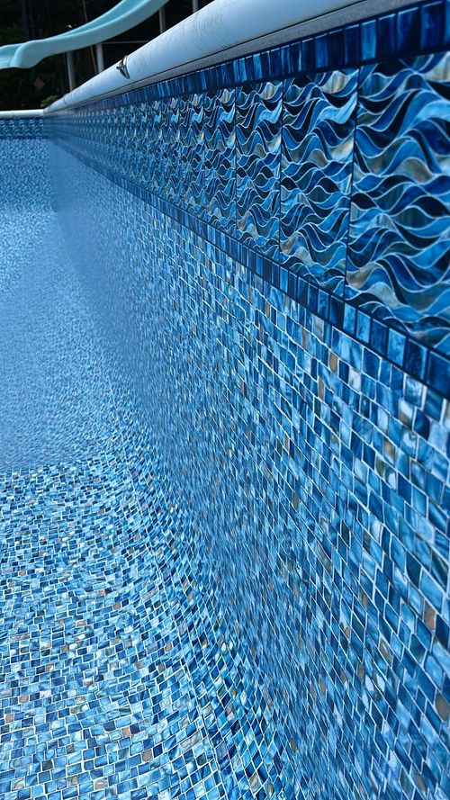 Blue pebble-covered floor and wall in a tiled pool or courtyard