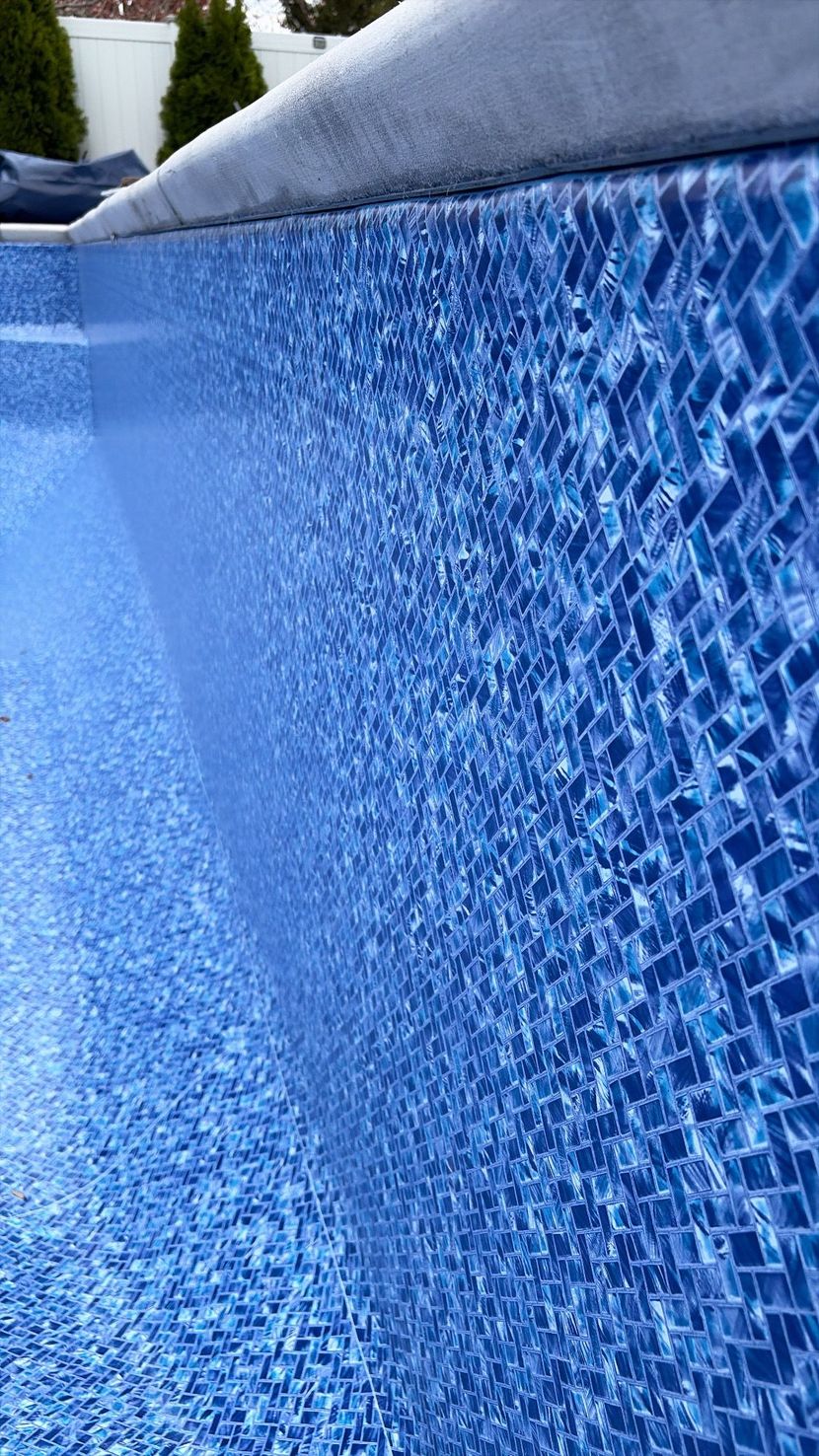 Blue rippling water surface with sunlight reflections and wave patterns