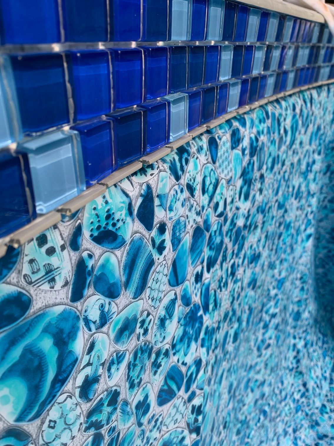 Modern pool with turquoise water and stone deck, viewed from above