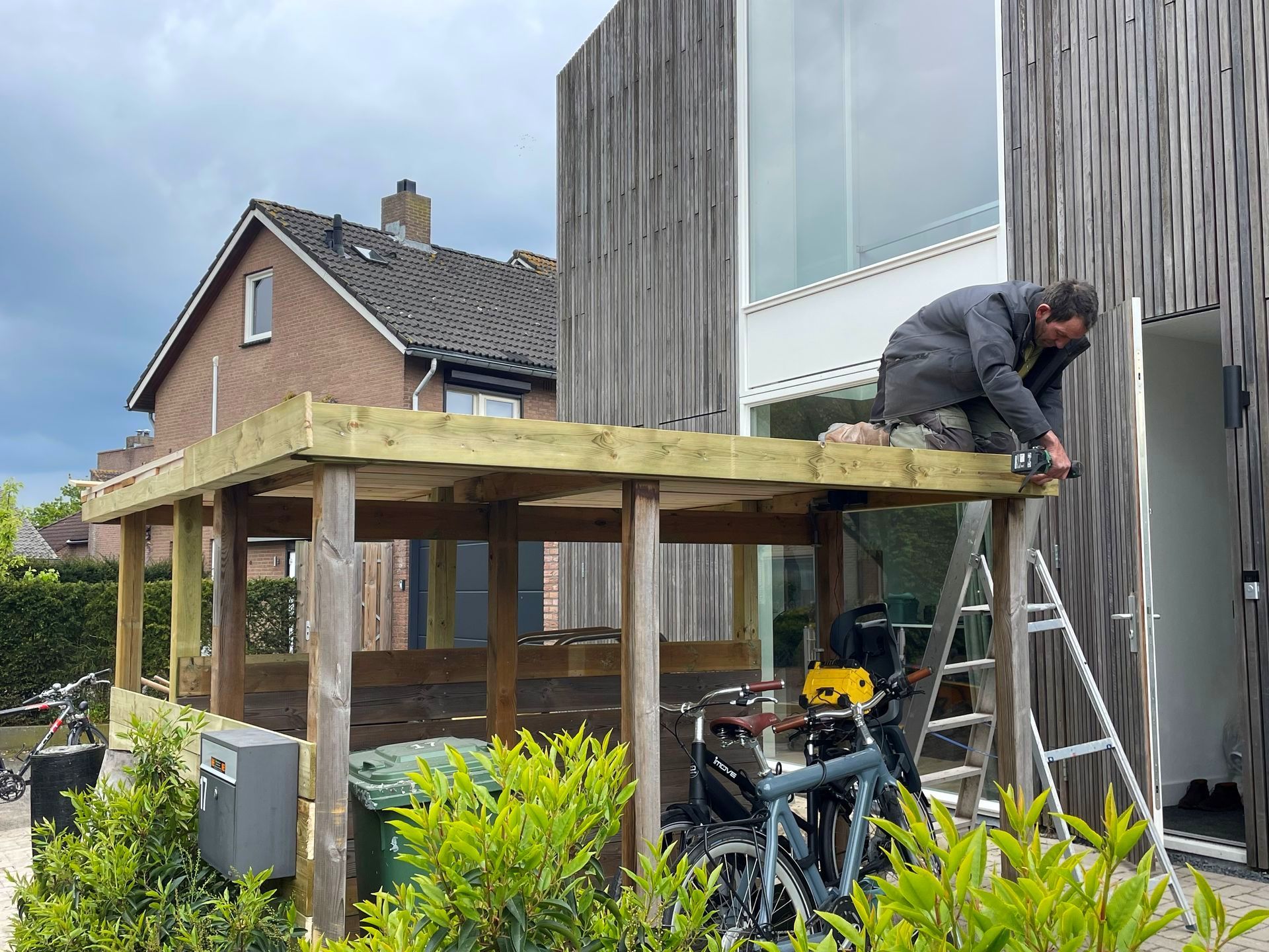 Plaatsing van een houten overkapping binnen een doordacht tuinontwerp